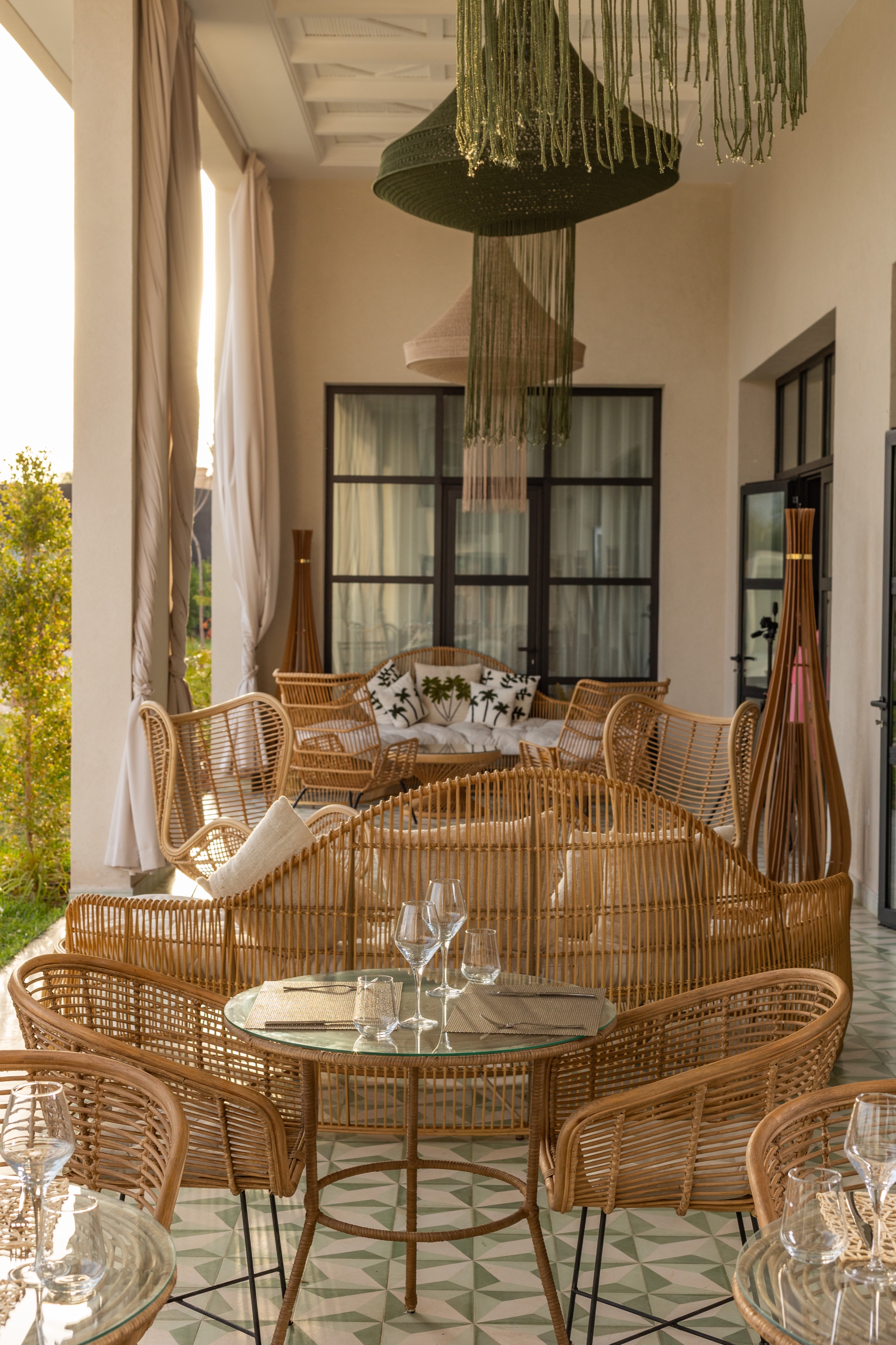 Tables et fauteuils en rotin sur la terrasse couverte de Yin Hotel