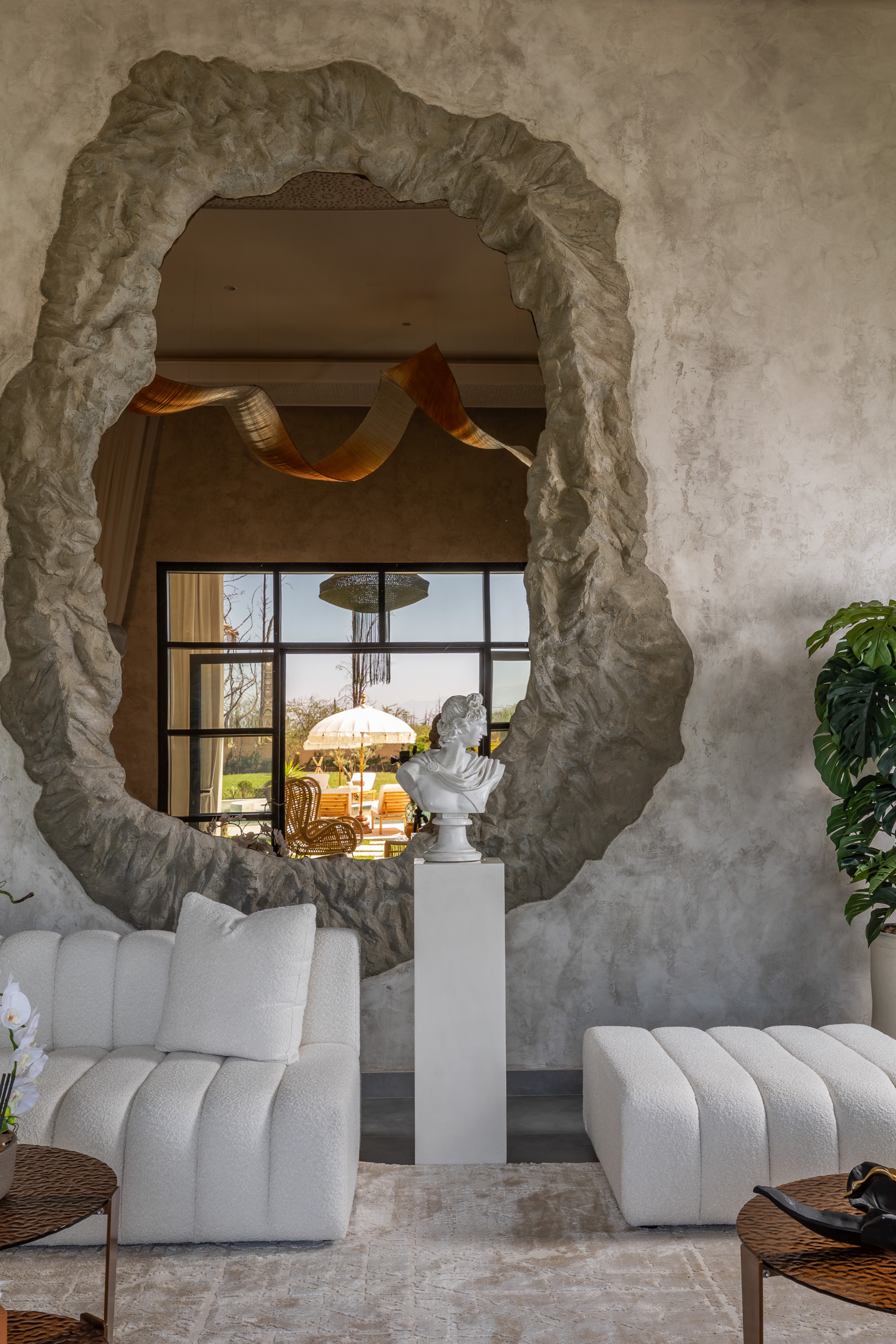 Miroir sculpté reflétant les fenêtres et le jardin de Yin Hotel
